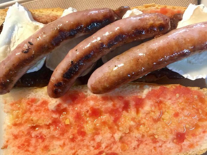 Bocadillo de salchichas con cebolla y queso de cabra